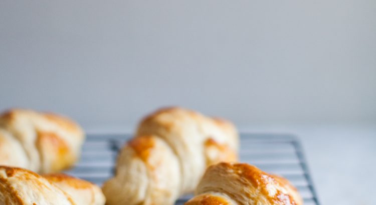 Homemade croissants on a wire cooling rack